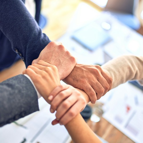 4 Menschen haken Arme ineinander